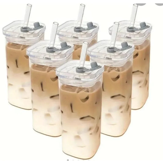 Multiple square transparent coffee cups with lids and straws, filled with a beverage, presented on a white background.