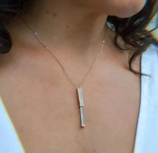 A person wearing a trendy zircon inlaid pendant necklace in silver color, with the pendant centered in the frame.